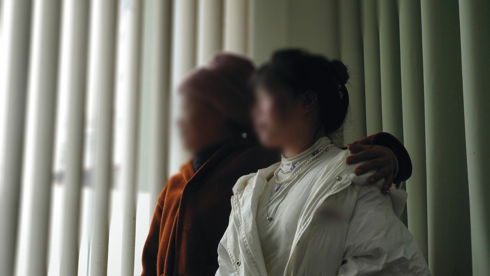 Ngoc un viņas meita Mien skatās pa logu.