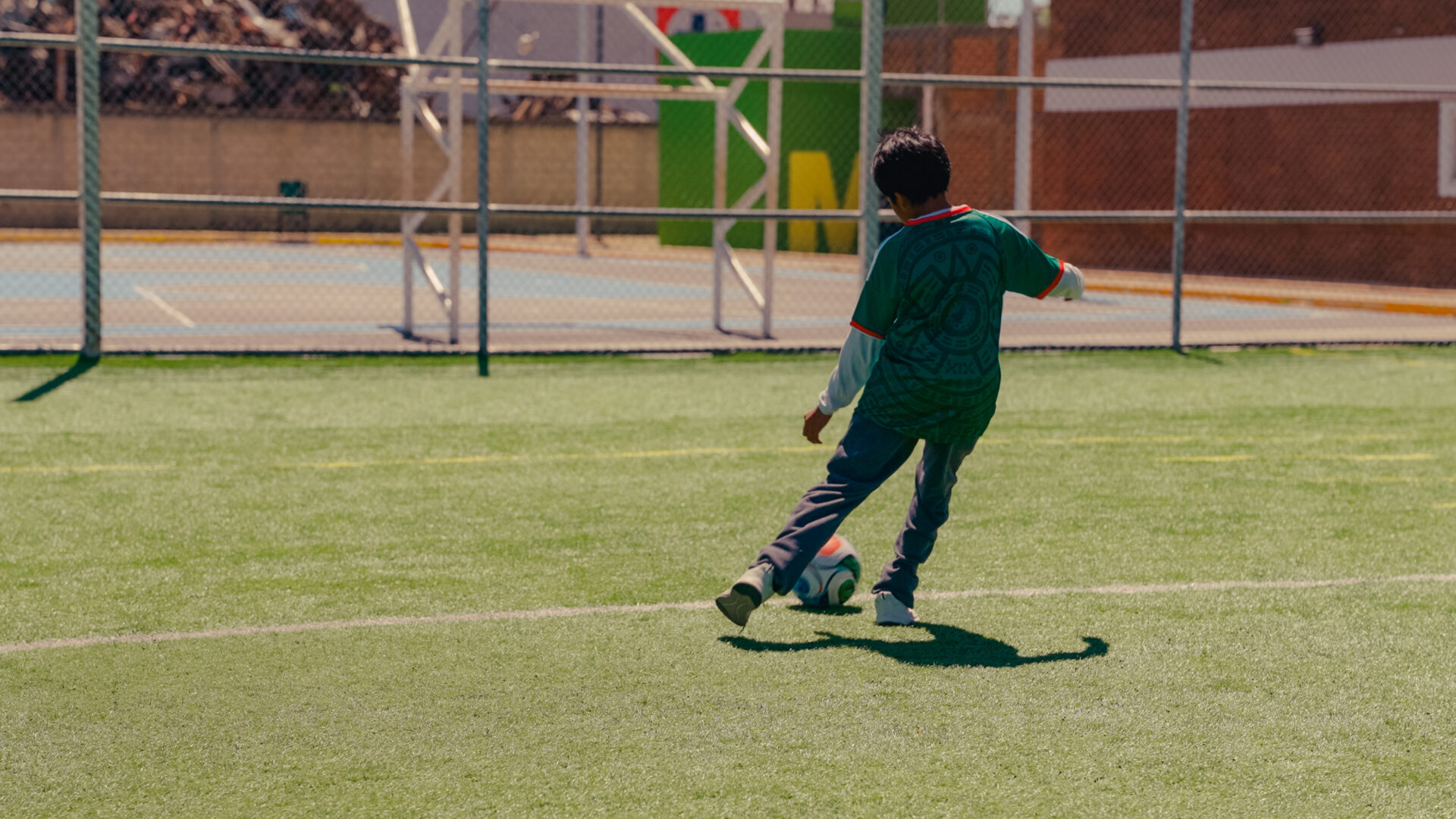 Zēns spēlē futbolu.